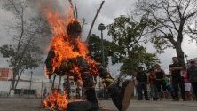 Последователи на правителството на Никола Мадуро горят кукла, представляваща образа на президента на САЩ- Доналд Тръмп, като форма на протест и част от честванията за Страсната седмица във Венецуела.