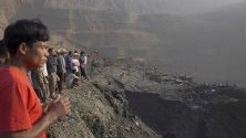 Хората се събират близо до мястото на свлачище в минна нефтена мина в Хпакант, щат Качин, Северна Мианмар, 23 април 2019 г. Според данните се смята, че над 50 миньори са погребани под купчина земя, изместена от свлачището.