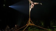 Акробат от цирка Cirque du Soleil прави перформънс на сцената по време на премиерата на шоуто Totem в Женева, Швейцария.