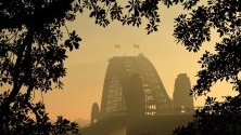 Тънък дим покрива пристанището на Сидни и по-голямата част на Сидни в Сидни, Австралия.