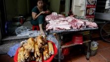 Жена продава свинско месо на пазарен щанд в Ханой, Виетнам. Виетнам е убил над 1,7 милиона прасета, или приблизително 5 процента от популацията на свине в страната.