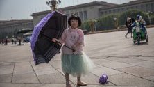 Китайско момиче стои с чадър на площад Тянанмън в Пекин, Китай. Тази година се отбелязва 30-ата годишнина от протестите на площад „Тянанмън“ през 1989 година. Между 15 април и 04 юни 1989 г. студенти, интелектуалци и активисти участваха в поредица от демонстрации срещу китайската комунистическа партия, където последващите репресии от страна на властите предизвикаха голям брой смъртни случаи и наранявания на цивилни.