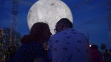Хора гледат инсталация от британския художник Люк Джерам, представена в Научния център Коперник във Варшава, Полша. Инсталацията показва луна с диаметър седем метра. Всеки сантиметър на сферата е пет километра от повърхността на действителната луна.