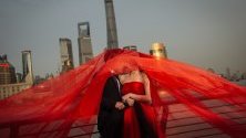 Китайска двойка позира за снимките си преди сватбата на Бунд пред кулата Шанхай в района на Пудонг, Шанхай, Китай. 