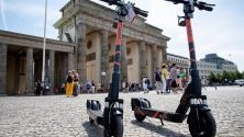 Електрически скутери, които се отдават под наем, стоят пред Бранденбургската врата в Берлин, Германия.