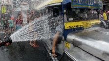 Хора обляни с вода по време на фестивала Wattah-Wattah   на  празника на Свети Йоан Кръстител, на изток от Манила, Филипините.