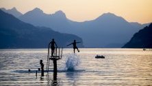 Младежи се радват на вечерта на езерото  Walensee в Швейцария.