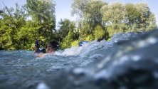 Човек  плува в река Ааре в горещ летен ден,  Берн, Швейцария.