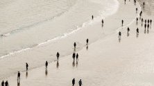 Хора се разхождат по брега на плажа Ла Конча, в Сан Себастиан, Испания.