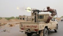 Член на йеменското правителство стреля с картечница по време на боевете срещу бунтовниците от Хати в покрайнините на пристанищния град Ходейда, Йемен.