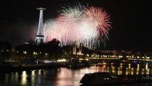 Фойерверки осветяват небето в близост до Айфеловата кула като част от празненствата на Деня на Бастилията в Париж, Франция. 