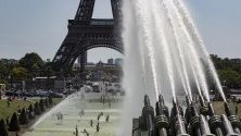 Хора се охлаждат във фонтаните на площад Трокадеро, срещу Айфеловата кула, в Париж, Франция. 