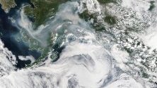 Снимка предоставена от НАСА на сателитно изображение, показващо гъст дим от огън, завихрящ се над щата Аляска, САЩ.