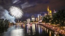 Хора се наслаждават на фойерверки осветяващи небето, след края на  фестивал във Франкфурт,Германия.