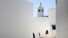 Гледка към тясна улица, водеща към джамията Al-Ghofrane  в село Сиди Бу Саид близо до Тунис.