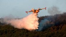Боен самолет се бори с пламъците на  горски пожар в Сан Илдефонсо, Испания.