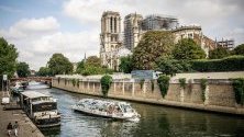 Туристическа лодка обикаля пред катедралата Нотр Дам в Париж, Франция.