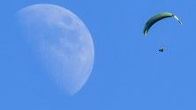 Парапланер лети покрай изгряващата луна в Ротах-Егерн, Германия.