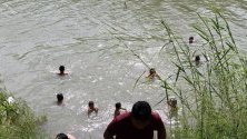 Мигранти от Латинска Америка се къпят в Рио Гранде, в мексиканския щат Тамаулипас.
