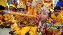 Деца от държавно училище облечени като бог Кришна и богиня Радха по време на фестивала Джанмашти, отбелязващ рождението на Кришна, в Бопал, Индия.