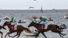 Жокеи се надпреварват с конете си по време на първия ден от 174-тите конни състезания на плажа Санлукар де Барамеда, Кадис, Испания.