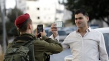 Израелски войници проверяват паспорта на палестински шофьор на КПП в Хеброн.