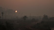 Гъст дим и прах от пожарите в дъждовните гори по Амазонка край Порто Вельо, Бразилия. Според правителството пожарите намаляват.