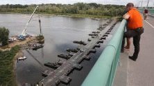 Полски войници изграждат временна канализация през понтонен мост, за да се спрат боклуците, изхвърляни в река Вистула след аварията в канализацията във Варшава.