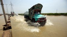 Камион преминава през наводнен път след проливни дъждове в Карачи, Пакистан.