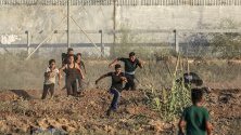 Палестинчета бягат по време на сблъсъци на границата между Израел и Газа.