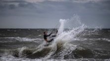Кайтсърфист в действие по време на силно ветровито време на брега на Балтийско море близо до Росток, Германия.