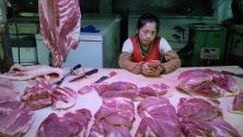 Продавач на свинско месо в Пекин, Китай. Властите пускат тонове замразено свинско от държавния резерв, след като Пекин унищожи над 1 милион прасета в опит да ограничи африканската чума.