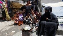 Жена приготвя храна на деца във временен лагер в Сана, Йемен. Конфликтът между бунтовниците хути и правителствените части от 2015 г. досега е довел до над 3,6 милиона бежанци. 
