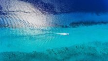 Лодка плува през рифа Паланкар - един от най-големите в света, на остров Косумел, Мексико. Властите временно спряха достъпа на туристите до района в опит да защитят коралите.