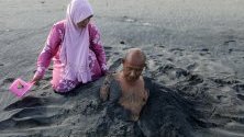 Болен е засипан с черен пясък - част от традиционно местно лечение, Банда Ачех, Индонезия. Местните вярват, че черният пясък може да лекува и предотвратява сърдечните удари и хипертонията.