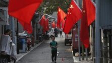 Китайски национални знамена в квартал Хутонг в Пекин. Страната се готви да отбележи утре 70-годишнината от основаването на народната република.