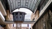 Реплика на наблюдателна кула от времето на ГДР и парчета от оригиналната Берлинска стена са изложени в мол в Берлин.