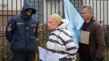 Украински активисти, единият облечен като затворник и с маска на руския президент Владимир Путин, пресъздават Хагския трибунал пред руското посолство в Киев.