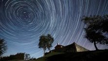 Дълга експозиция на звезди над параклис в град Комийас, Испания, заснета по време на Драконидите - първите метеорни потоци през есента.