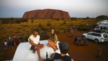Туристи се снимат на фона на Улуру - вторият по големина скален монолит на планетата, Северните територии на Австралия.