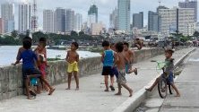 Деца си играят в гето в Манила, Филипините. Страната е на път да се превърне в инкубатор на предотвратими болести, обхваната от епидемия на вируса денга и морбили, както и новообявена епидемия на полиомиелит. Основната причина са страховете от ваксиниране.