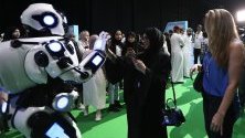 Посетители разглеждат робот по време на конференция за изкуствения интелект в Дубай.