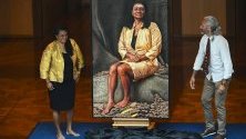 Бившият сенатор Нова Перис позира в парламента пред свой портрет, дело на аборигенски художник, Канбера, Австралия.