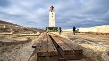 Подготовка за преместване на фара в Ютланд, Дания. Фарът ще бъде преместен заради ерозия на брега. За целта се използват ролкови релси.
