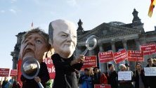 Протестиращи в защита на климата с маски на канцлера Ангела Меркел и финансовия министър Шолц пред Бундестага.