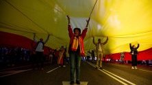 Протестиращи носят най-голямото правено някога в Испания национално знаме по време на демонстрация в Мадрид, организирана от дясната партия "Вокс" в защита на единението в страната.