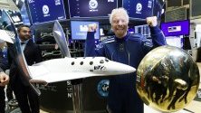 Ричард Брансън, основател на Virgin Galactic, позира на фондовата борса в Ню Йорк с модел на космически кораб по повод първия ден от търгуването на акции на Virgin Galactic Holdings на борсата.