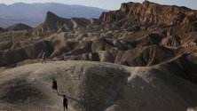 Туристи се разхождат по Забриски Пойнт в пустиня в националния парк Death Valley в Калифорния. Това е едно от най-горещите и сухи места в света.