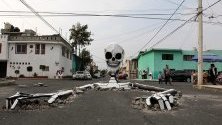 Макет на скелет, излизащ от дупки по улицата, в квартал Тлауак, Мексико сити. Скелетът е дело на Раймундо Медина, жител на мексиканската столица, за Деня на мъртвите и е призив към властите да оправят улиците.