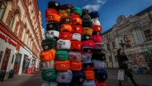 Жителка на Москва минава край купчина зимни шапки за продан в руската столица.